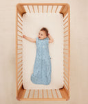 Baby wearing a blue ergoPouch sleeping bag that is made from organic, breathable materials.