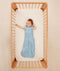 Baby wearing a blue ergoPouch sleeping bag that is made from organic, breathable materials.