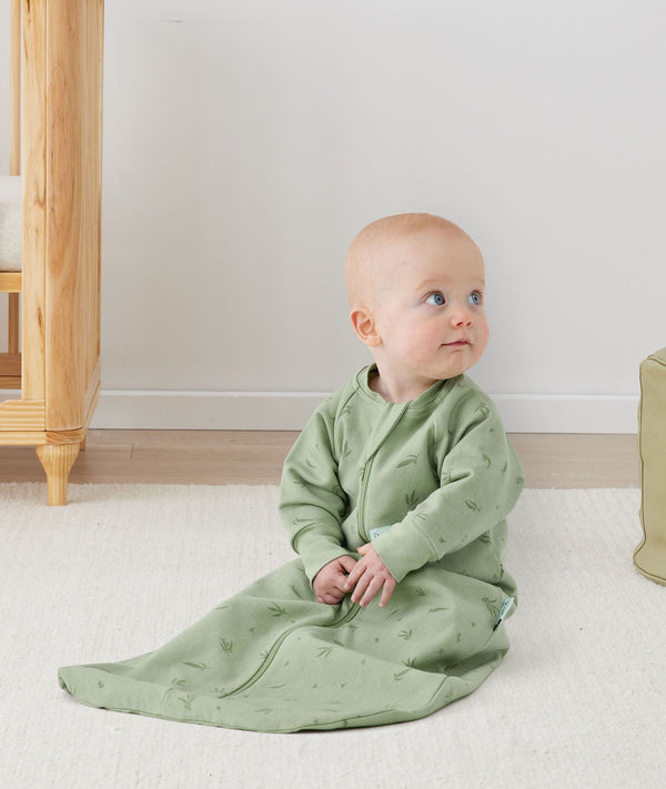 Newborn sitting, wearing an ergoPouch Jersey Sleeping Bag 1.0 TOG Sleeved Willow
