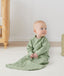Newborn sitting, wearing an ergoPouch Jersey Sleeping Bag 1.0 TOG Sleeved Willow