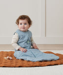 Newborn sitting, wearing an ergoPouch Jersey Sleeping Bag 2.5 TOG Dragonflies