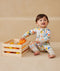 Baby wearing an ergoPouch Long Sleeve Layer 1.0 TOG Fruit Salad