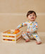 Baby wearing an ergoPouch Long Sleeve Layer 1.0 TOG Fruit Salad