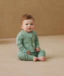 Newborn sitting, wearing an ergoPouch Long Sleeve Layer 1.0 TOG Sweet Orchard