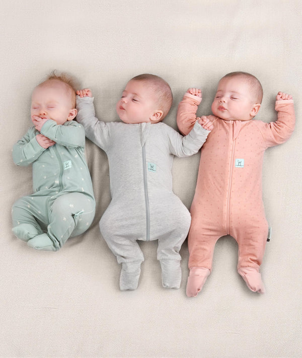 Newborn baby wearing an ergoPouch Long Sleeve Layer 0.2 TOG Berries