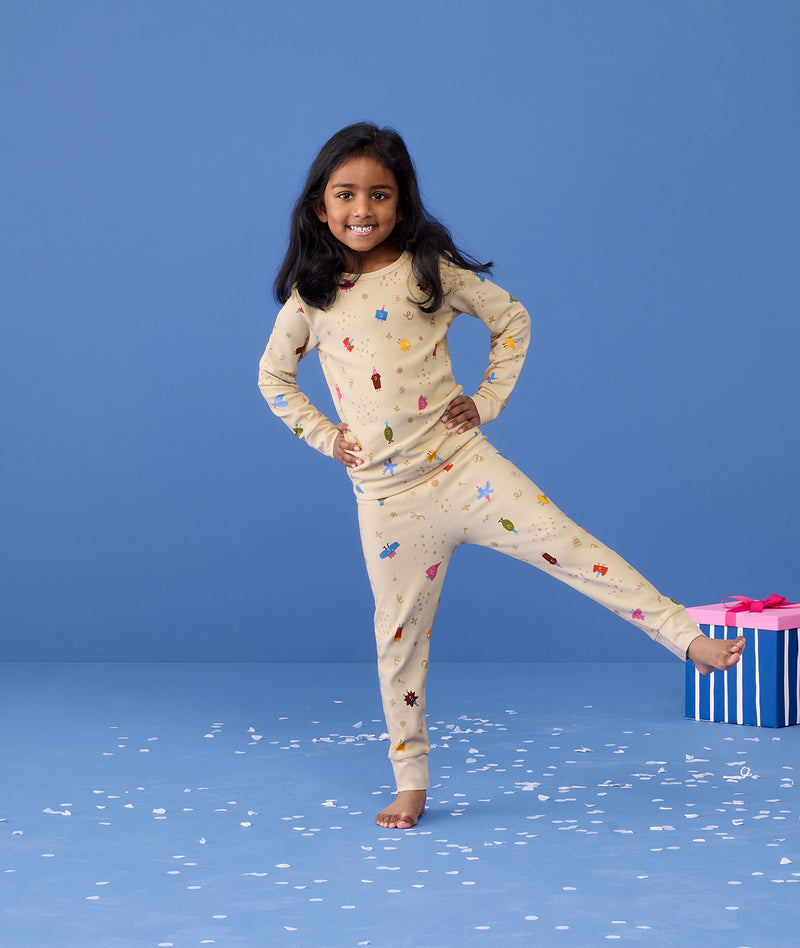 Preschooler wearing 2-piece ergoPouch Long Sleeve Pyjamas 1.0 TOG Birthday Blobs