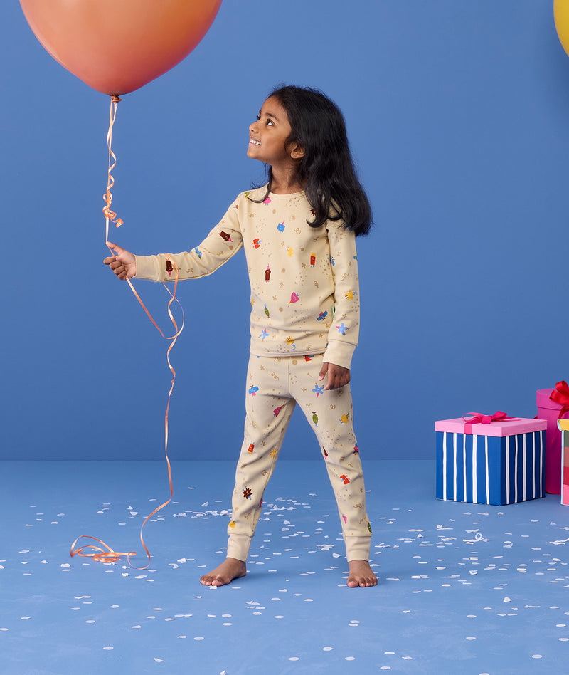 Preschooler wearing 2-piece ergoPouch Long Sleeve Pyjamas 1.0 TOG Birthday Blobs