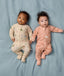 Two babies lying side by side wearing ergoPouch Long Sleeve Layers 1.0 TOG in Savannah and Elephant Parade