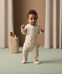 Infant standing in ergoPouch Long Sleeve Layer 1.0 TOG Savannah with foot cuffs folded over to retain warmth and protect skin.