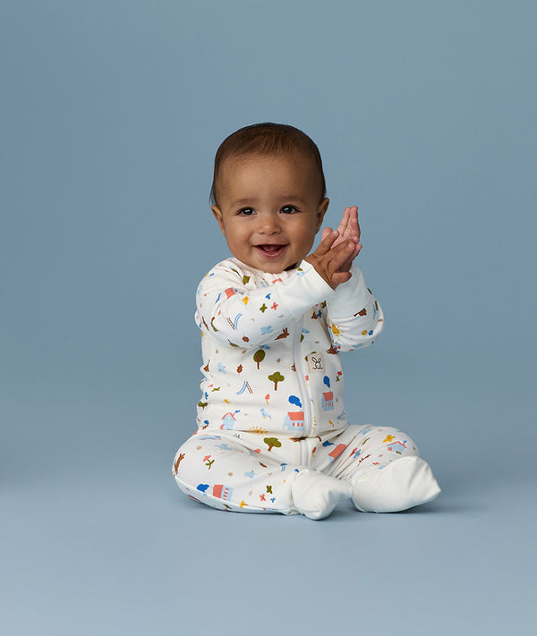 Happy infant sitting in an ergoPouch Long Sleeve Layer 1.0 TOG Daydream
