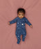 Baby lying in an ergoPouch Long Sleeve Layer 1.0 TOG Daydream with the fold-over cuffs