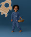 Toddler smiling in an ergoPouch Long Sleeve Layer 1.0 TOG Daydream whilst holding a basket
