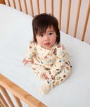 Infant sitting up looking into the camera wearing ergoPouch Long Sleeve Layer 1.0 TOG in Bon Appetit