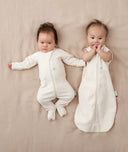 Two babies, one wearing a Cocoon Swaddle Bag 1.0 TOG Oatmeal Marle and the other in a Layer
