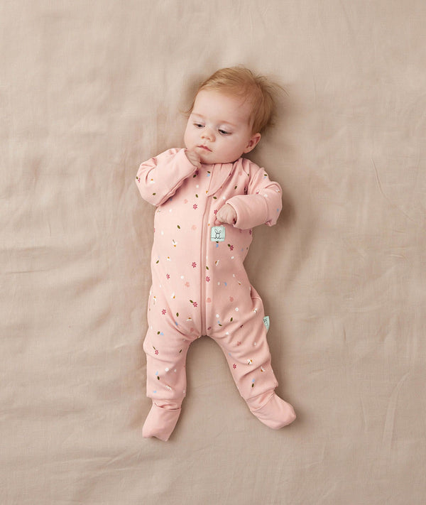 Newborn baby wearing an ergoPouch Long Sleeve Layer 1.0 TOG Daisies
