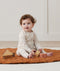 Baby wearing an ergoPouch Long Sleeve Layer 1.0 TOG Oatmeal Marle