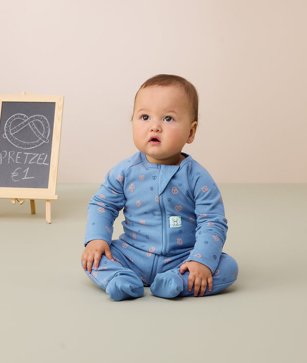 Infant sitting in ergoPouch Long Sleeve Layer 1.0 TOG Petit Pretzel