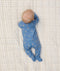 Baby lying on its stomach wearing ergoPouch Long Sleeve Layer 1.0 TOG in Petit Pretzel