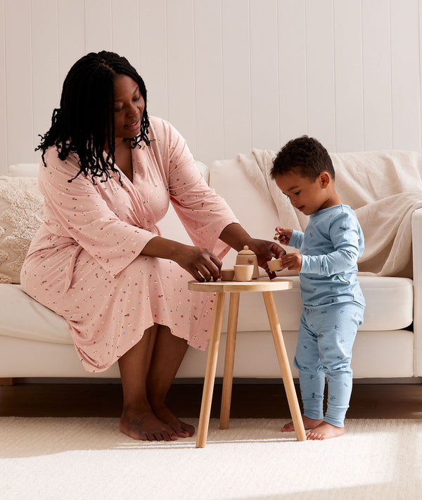 Mum wearing a an ergoPouch Matchy Matchy Robe Daisies, playing with a toddler