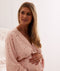 Mum wearing a an ergoPouch Matchy Matchy Robe Daisies, embracing her baby bump