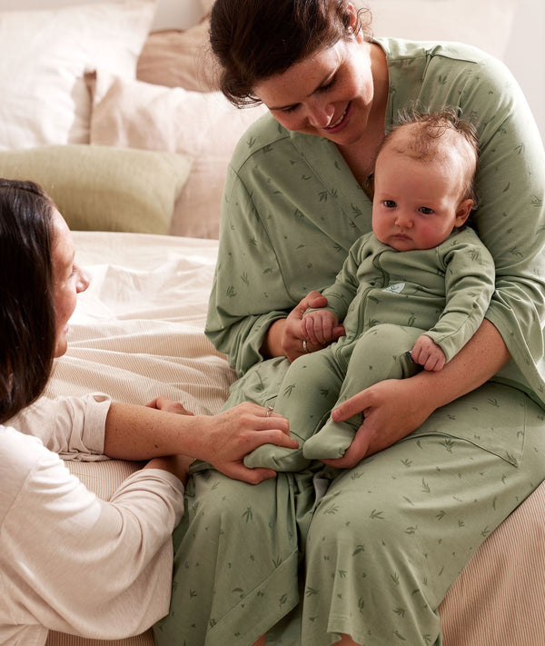 Mum wearing a an ergoPouch Matchy Matchy Robe Willow, holding a baby in a matching Layer