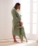 Toddler hugging the legs of a pregnant mum, both wearing a matching ergoPouch sleepwear