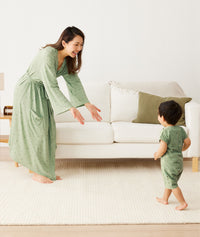 Mum wearing a an ergoPouch Matchy Matchy Robe Willow, reaching out for her toddler in matching sleepwear