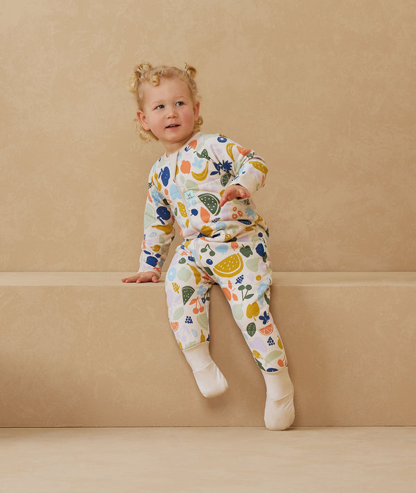 Toddler wearing an ergoPouch Sleep Onesie 2.5 TOG Fruit Salad