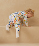 Toddler wearing an ergoPouch Sleep Onesie 2.5 TOG Fruit Salad