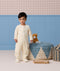 Toddler wearing a cream patterned Sleep Onesie with covered feet standing near a wooden toy xylophone and a plush cat.