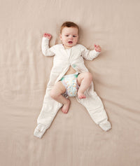 Baby wearing an ergoPouch Sleep Onesie 2.5 TOG Oatmeal Marle, getting nappy changed