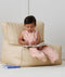 Toddler reading a book whilst wearing ergoPouch Sleep Suit Bag 0.2 TOG Daisies