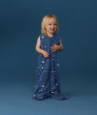 Smiling toddler wearing an ergoPouch Jersey Sleep Suit Bag 0.2 TOG Starbeam, a sleeping bag that converts to a sleep suit with legs.