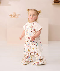 Toddler standing looking at the camera wearing ergoPouch Sleep Suit bag 1.0 TOG Bon Appetit