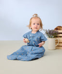 Toddler sitting wearing ergoPouch Sleep Suit bag 1.0 TOG Petit Pretzel