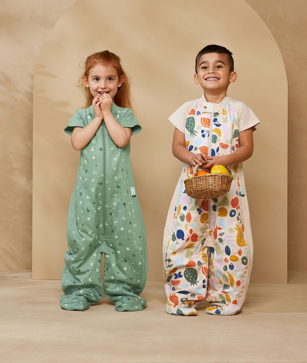Two preschool kids wearing a TOG-rated ergoPouch sleep suit bag, featuring cute, colourful prints.