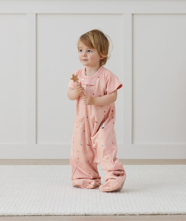 Toddler wearing an ergoPouch Sleep Suit Bag 1.0 TOG Daisies