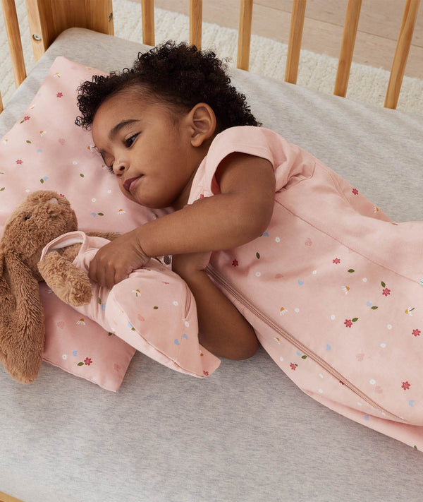 Toddler wearing an ergoPouch Sleep Suit Bag 1.0 TOG Daisies