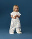 Toddler wearing an ergoPouch Sleep Suit Bag 1.0 TOG Daydream, a sleeping bag that converts to a sleep suit with legs by a four-way zipper feature. 