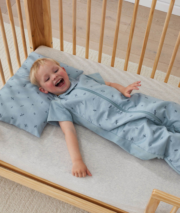 Toddler wearing an ergoPouch Sleep Suit Bag 1.0 TOG Dragonflies