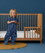 Toddler wearing an ergoPouch Sleep Suit Bag 1.0 TOG Starbeam, a sleeping bag that converts to a sleep suit with legs.