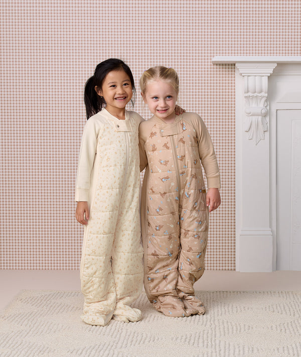 Two preschoolers standing side-by-side in full-length quilted Sleep Suit bags 2.5 TOG, smiling with an arm around each other.