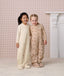 Two preschoolers standing side-by-side in full-length quilted Sleep Suit bags 2.5 TOG, smiling with an arm around each other.
