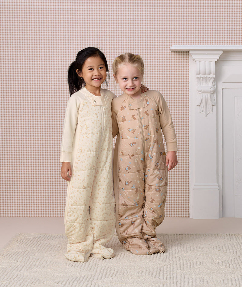 Two preschoolers standing side-by-side in full-length quilted Sleep Suit bags 2.5 TOG, smiling with an arm around each other.