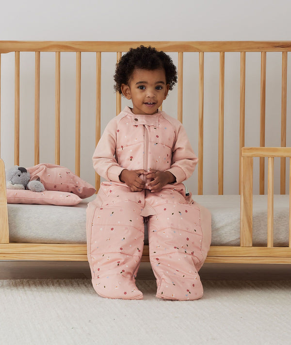 Toddler wearing a warm, ergoPouch Sleep Suit Bag 3.5 TOG Daisies