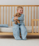 Toddler sitting on bed made with ergoPouch Organic Toddler Pillow And Case Dragonflies