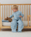 Toddler placing its teddy bear on an ergoPouch Organic Toddler Pillow Case Dragonflies