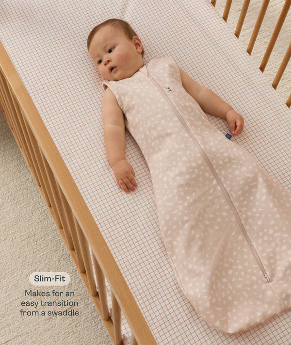 Infant wearing a sleeveless Sleeping Bag 1.0 TOG, lying inside a wooden cot with text highlighting 