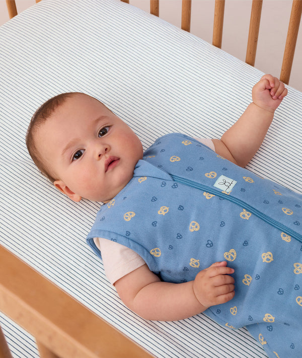 Baby wearing a blue ergoPouch sleeping bag that is made from organic, non-toxic materials.