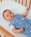 Baby wearing a blue ergoPouch sleeping bag that is made from organic, non-toxic materials.